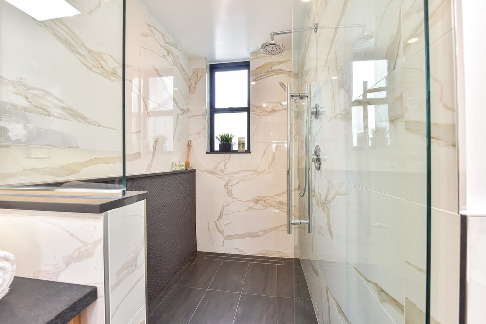 Photo of a large modern master bathroom in DC Metro with furniture-like cabinets, light wood cabinets, a freestanding tub, an open shower, a one-piece toilet, white tile, porcelain tile, white walls, porcelain floors, a vessel sink, granite benchtops, grey floor, a hinged shower door and white benchtops.