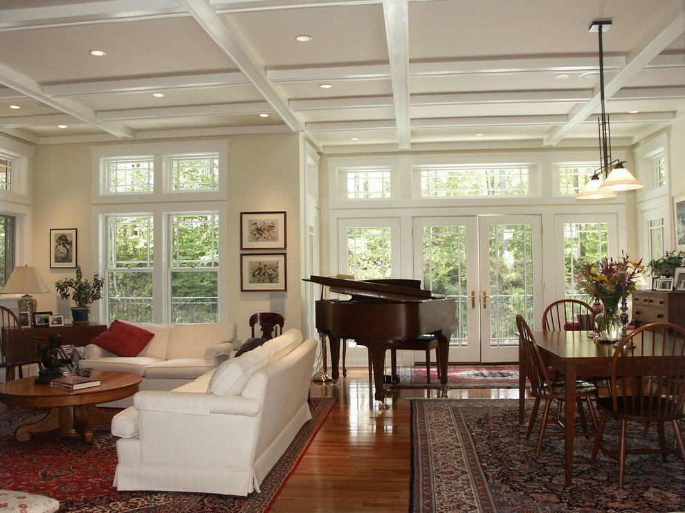 This is an example of a large traditional open concept family room in Boston with a music area, white walls, medium hardwood floors, no tv, a standard fireplace and a stone fireplace surround.