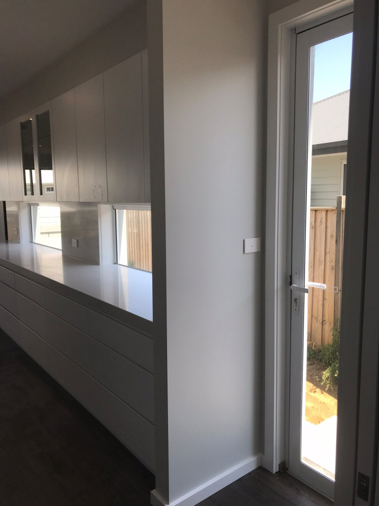 Inspiration for a large beach style galley eat-in kitchen in Central Coast with a drop-in sink, open cabinets, quartz benchtops, white splashback, stone slab splashback, dark hardwood floors, with island, brown floor and white benchtop.