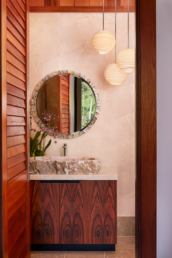 Photo of a tropical powder room in Hawaii with flat-panel cabinets, medium wood cabinets, beige walls, a vessel sink and granite benchtops.