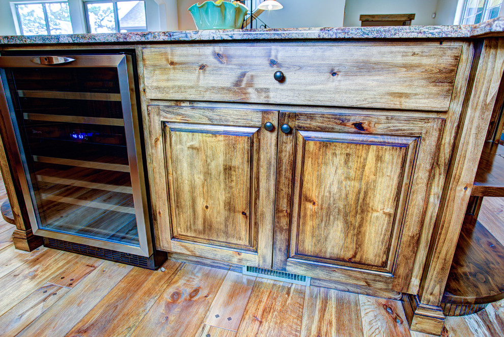 Kitchen pantry - large rustic u-shaped medium tone wood floor kitchen pantry idea with a drop-in sink, glass-front cabinets, medium tone wood cabinets, beige backsplash, stainless steel appliances and an island