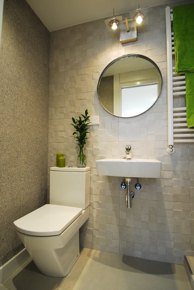 Inspiration for a mid-sized contemporary powder room in Madrid with a two-piece toilet and a wall-mount sink.