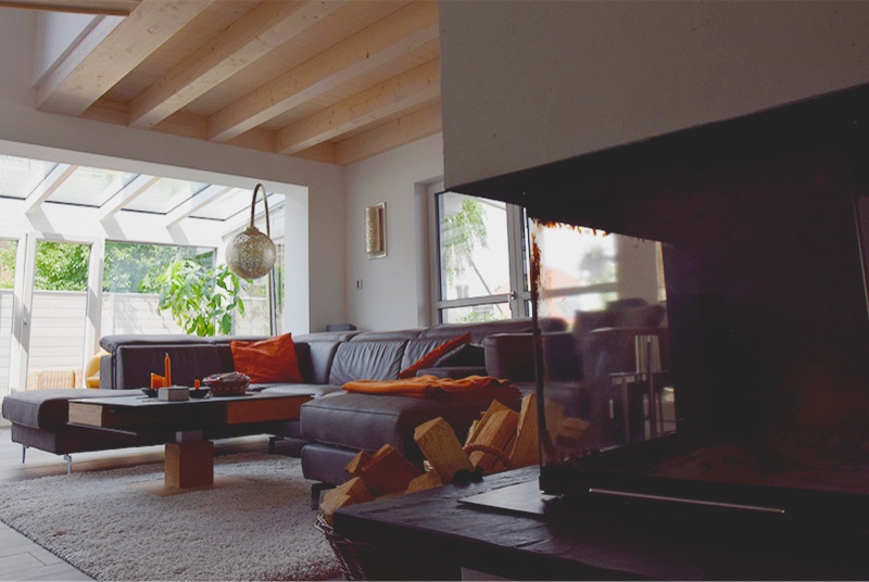 Mittelgroßes, Offenes Modernes Wohnzimmer mit weißer Wandfarbe, Tunnelkamin, verputzter Kaminumrandung und braunem Boden in Nürnberg