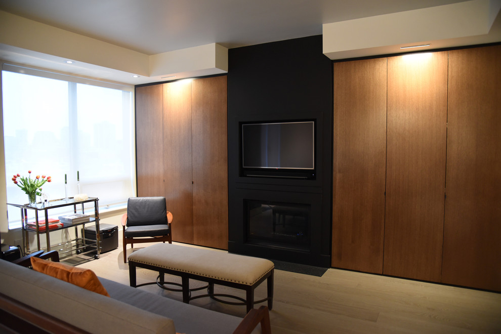 Photo of a small contemporary formal open concept living room in Toronto with light hardwood floors, a standard fireplace, a plaster fireplace surround, a wall-mounted tv and grey floor.