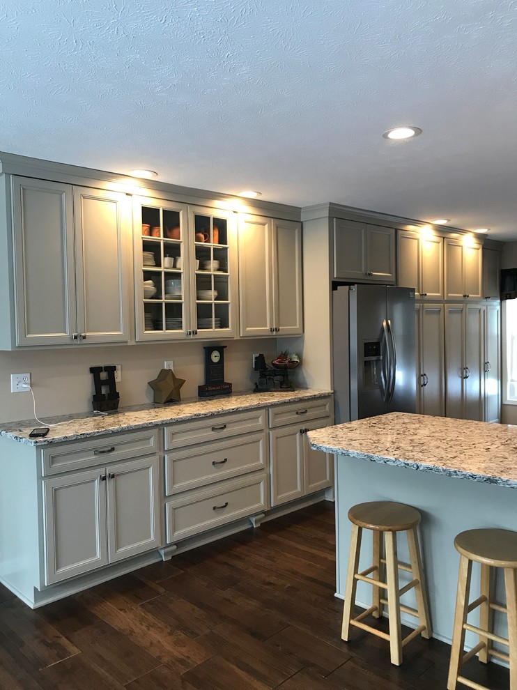 Design ideas for a large traditional galley separate kitchen in New York with an undermount sink, recessed-panel cabinets, grey cabinets, granite benchtops, stainless steel appliances, dark hardwood floors, a peninsula, brown floor and grey benchtop.