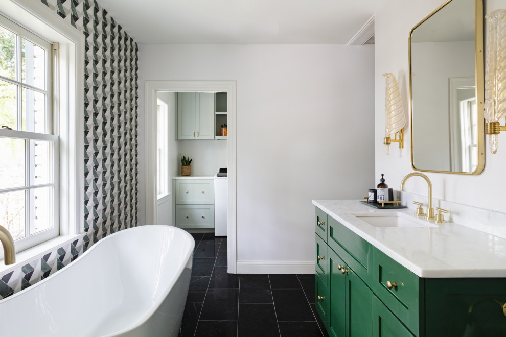 Aménagement d'une salle de bain éclectique de taille moyenne avec des portes de placards vertess, une baignoire indépendante, un mur blanc, un sol noir, un plan de toilette blanc, meuble simple vasque et meuble-lavabo encastré.