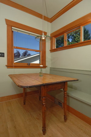 Example of a mid-sized transitional galley medium tone wood floor kitchen pantry design in Seattle with a farmhouse sink, glass-front cabinets, medium tone wood cabinets, wood countertops, multicolored backsplash, glass tile backsplash, stainless steel appliances, gray walls and an island