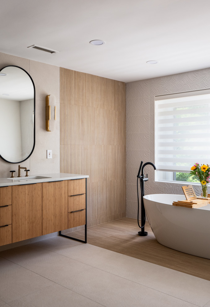 Example of a large trendy master beige tile and ceramic tile porcelain tile, beige floor and double-sink freestanding bathtub design in DC Metro with flat-panel cabinets, light wood cabinets, a one-piece toilet, beige walls, an undermount sink, quartzite countertops, beige countertops, a niche and a freestanding vanity