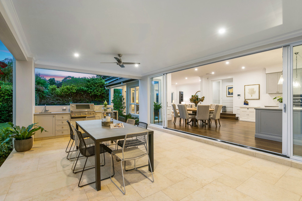 Large contemporary backyard verandah in Sydney with an outdoor kitchen, tile and a roof extension.