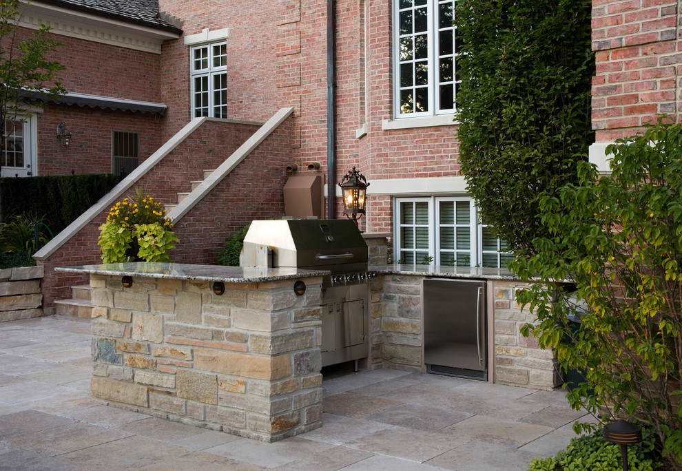 This is an example of a large traditional backyard rectangular lap pool in Chicago with a hot tub and natural stone pavers.