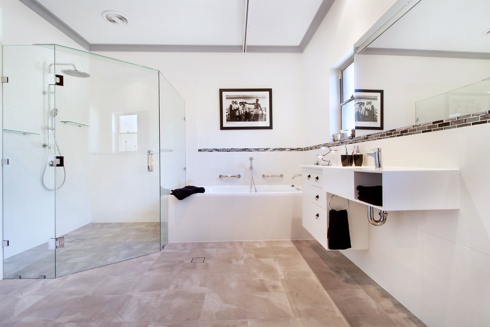 Large modern master bathroom in Adelaide with open cabinets, white cabinets, a drop-in tub, a curbless shower, a two-piece toilet, black and white tile, ceramic tile, white walls, cement tiles, an integrated sink, laminate benchtops, grey floor, a hinged shower door and white benchtops.