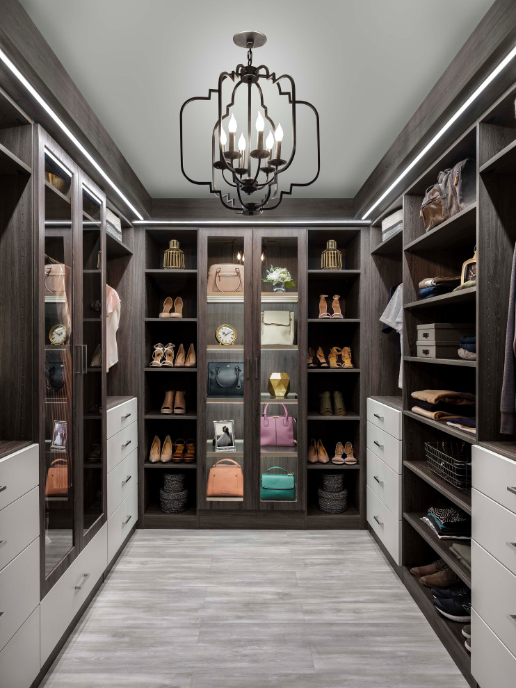 Design ideas for a mid-sized transitional gender-neutral walk-in wardrobe in New York with flat-panel cabinets, grey cabinets and grey floor.