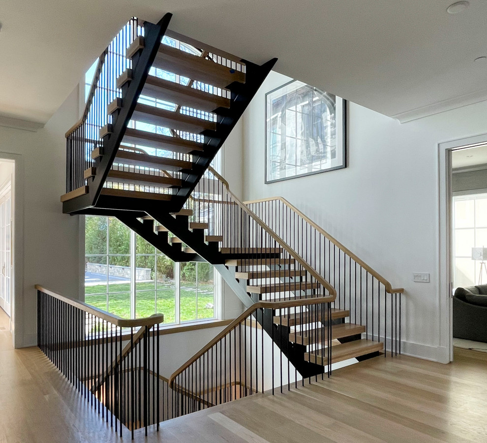 Стильный дизайн: огромная лестница на больцах в стиле модернизм с деревянными ступенями, перилами из смешанных материалов и стенами из вагонки - последний тренд