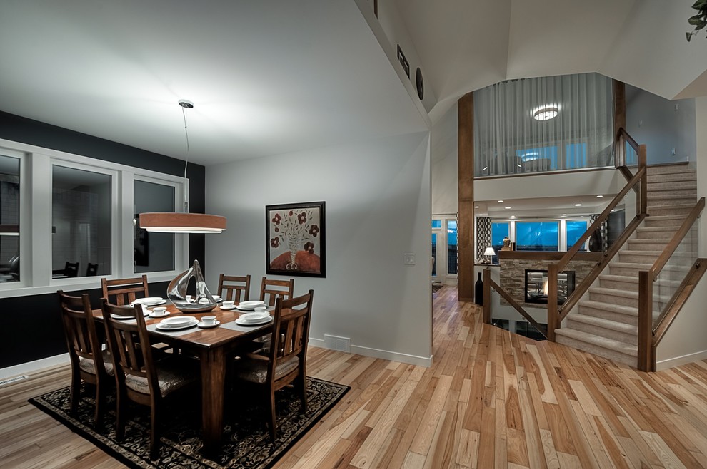 Dining room - mid-sized transitional medium tone wood floor dining room idea with white walls, a two-sided fireplace and a stone fireplace