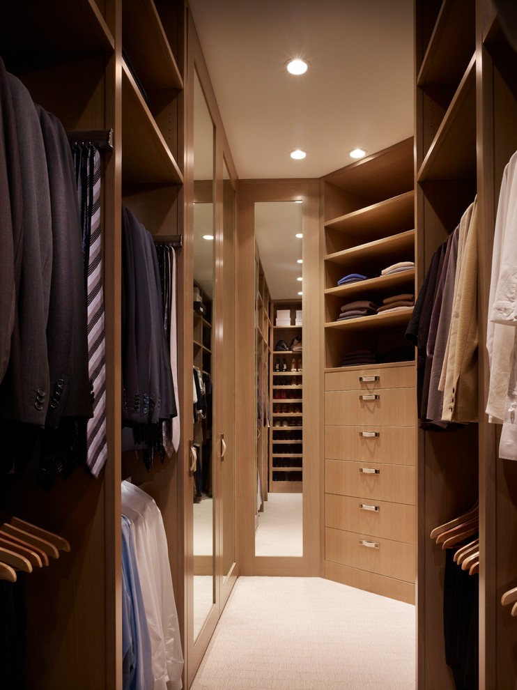 This is an example of a small contemporary men's walk-in wardrobe in Chicago with flat-panel cabinets, light wood cabinets and carpet.