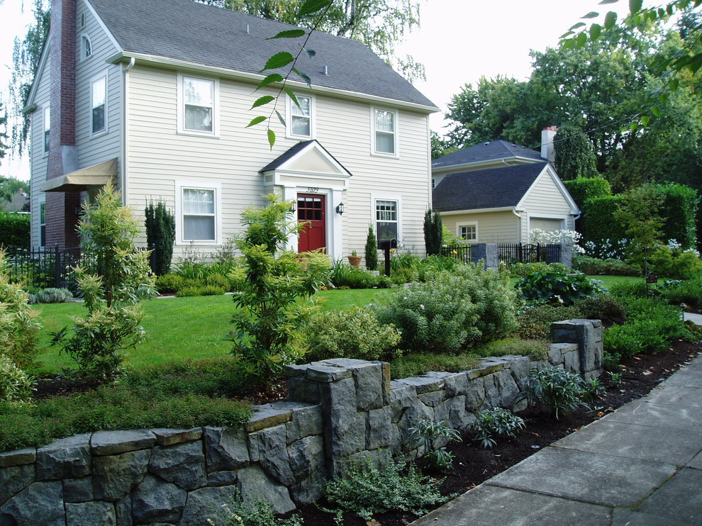 Large traditional front yard partial sun formal garden in Portland with a retaining wall.