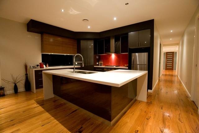 Small modern l-shaped kitchen pantry in Melbourne with flat-panel cabinets, black cabinets, limestone benchtops, red splashback, ceramic splashback and with island.