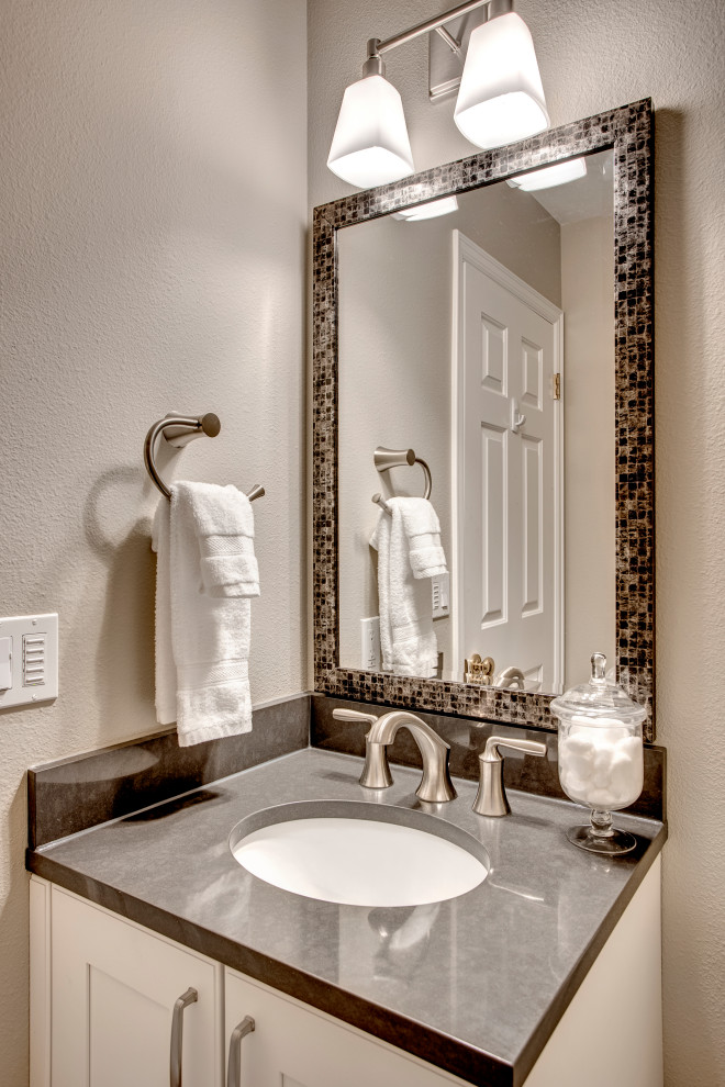 Small transitional medium tone wood floor and brown floor powder room photo in Seattle with shaker cabinets, white cabinets, a one-piece toilet, beige walls, an undermount sink, quartz countertops, gray countertops and a built-in vanity