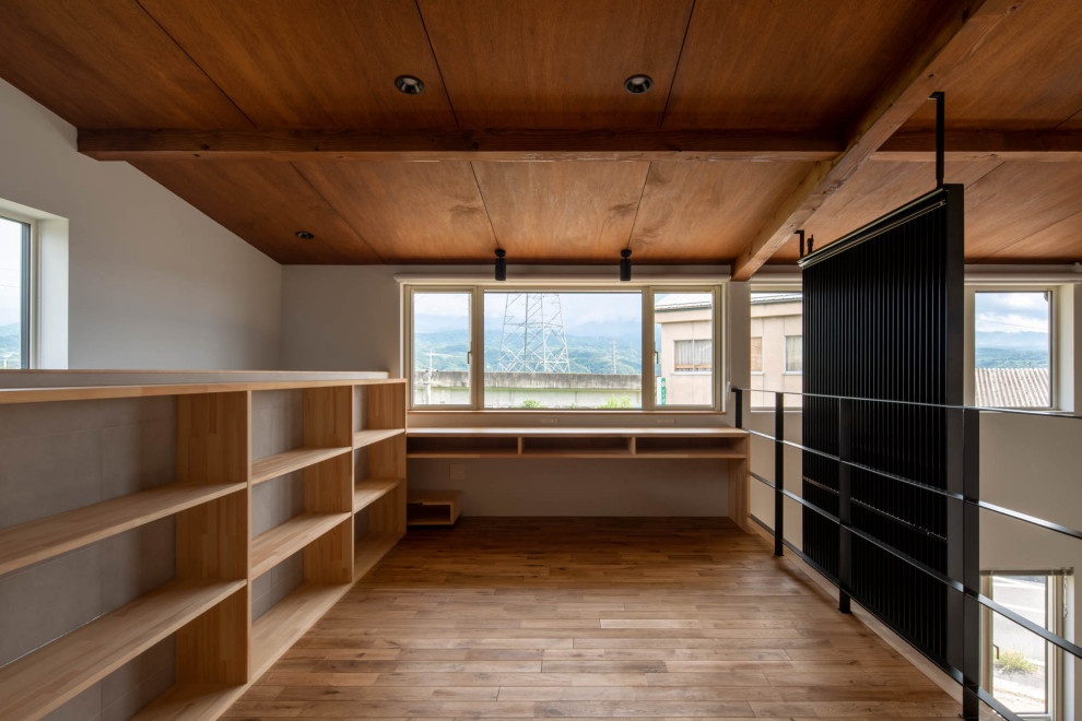 他の地域にあるおしゃれなファミリールーム (グレーの壁、無垢フローリング) の写真