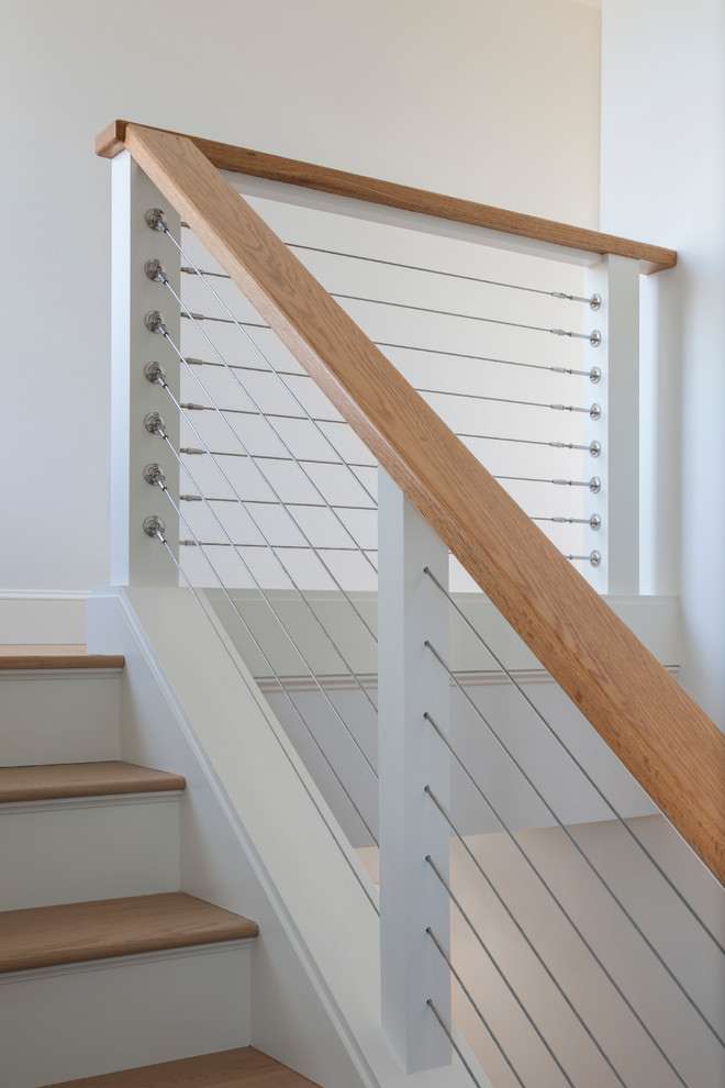 Пример оригинального дизайна: угловая лестница в стиле неоклассика (современная классика) с деревянными ступенями, крашенными деревянными подступенками и перилами из тросов