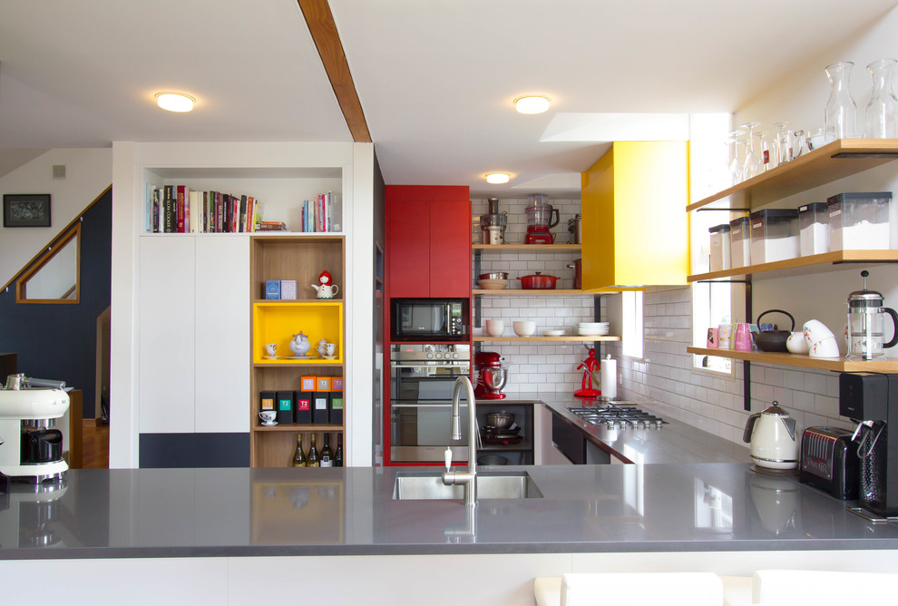 Photo of a mid-sized contemporary eat-in kitchen in Auckland with a single-bowl sink, stainless steel benchtops, white splashback, subway tile splashback, stainless steel appliances, medium hardwood floors and grey benchtop.