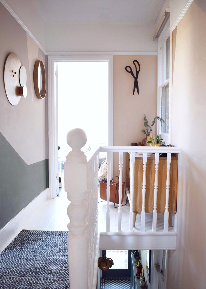 Inspiration for a small contemporary hallway in London with pink walls, painted wood floors and white floor.