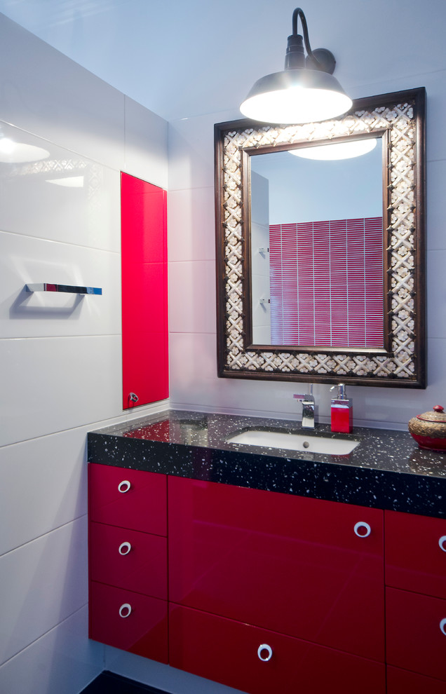 This is an example of a large eclectic powder room in Melbourne with an undermount sink, flat-panel cabinets, red cabinets, engineered quartz benchtops, red tile, white walls, black floor, ceramic tile, porcelain floors and a one-piece toilet.