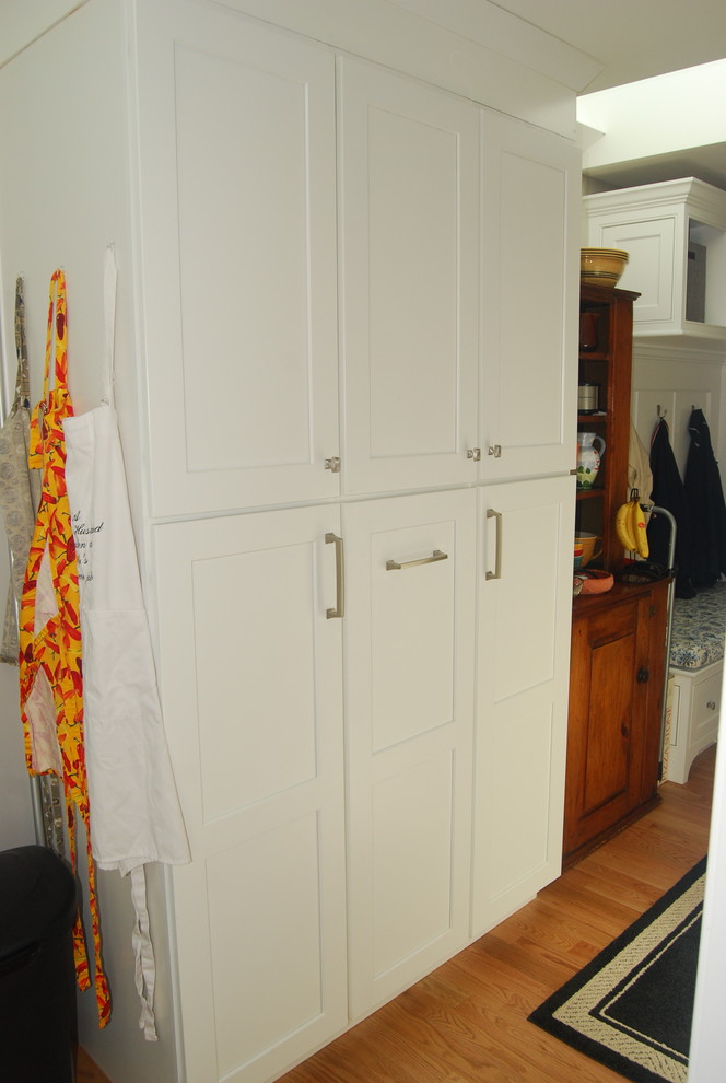 This is an example of a traditional utility room in Boston with light hardwood floors.