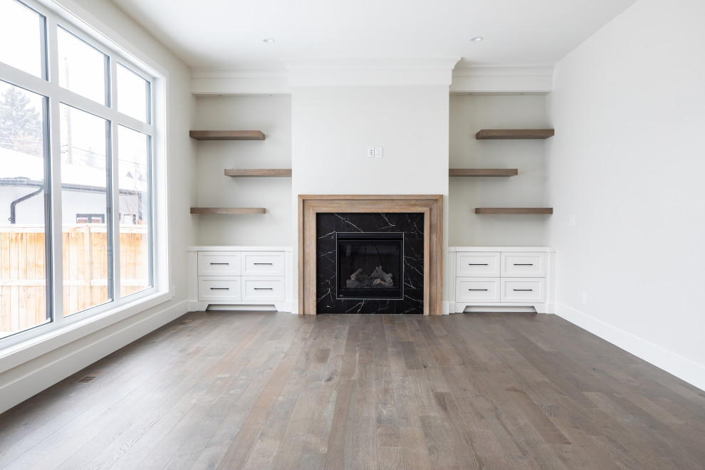 Inspiration for a mid-sized traditional open concept family room in Calgary with white walls, medium hardwood floors, a standard fireplace, a tile fireplace surround, a wall-mounted tv and brown floor.