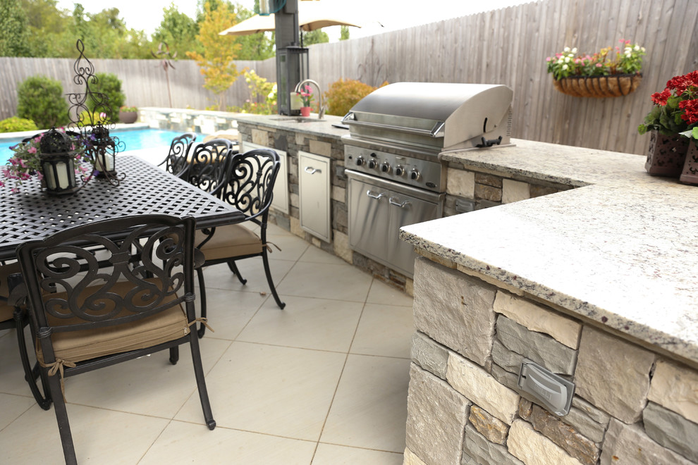 Large transitional backyard tile patio kitchen photo with a gazebo