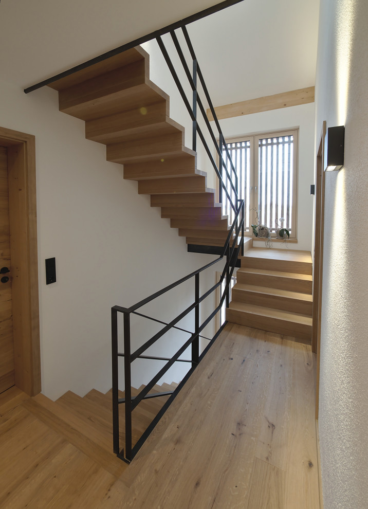 Diseño de escalera actual con escalones de madera y barandilla de metal