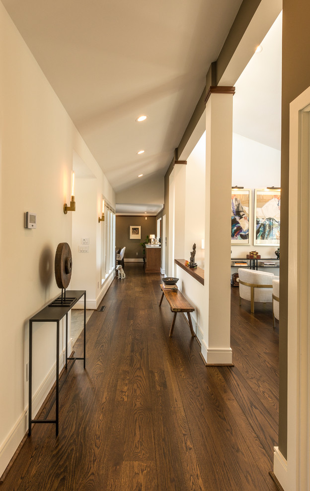 Photo of a mid-sized transitional entry hall in Other with beige walls, dark hardwood floors and brown floor.