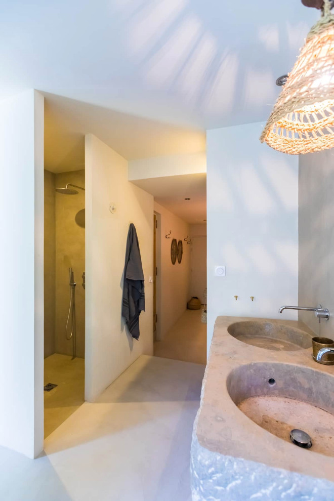 Inspiration pour une salle de bain principale méditerranéenne avec une douche à l'italienne, sol en béton ciré, un lavabo posé, un plan de toilette en calcaire et meuble double vasque.