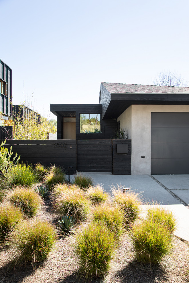 Photo of a mid-sized modern one-storey black house exterior in San Francisco with wood siding, a clipped gable roof, a shingle roof and a black roof.