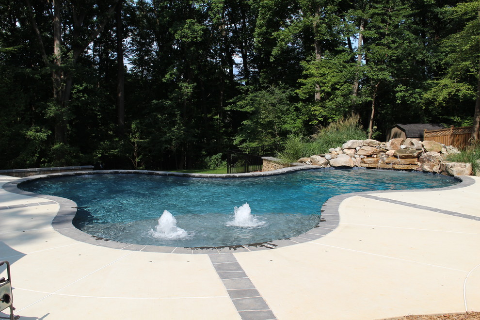 Large mountain style backyard custom-shaped natural pool fountain photo in DC Metro with decking