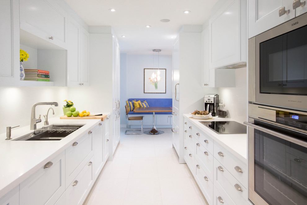 Design ideas for a large contemporary galley eat-in kitchen in Toronto with a double-bowl sink, shaker cabinets, white cabinets, quartz benchtops, white splashback, porcelain floors, stainless steel appliances and no island.