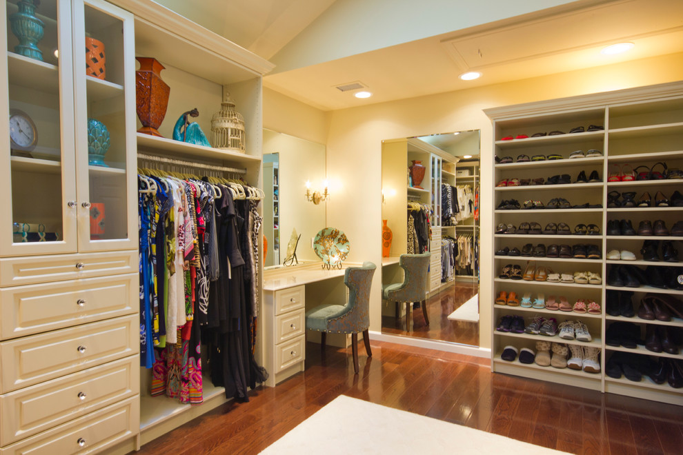 Design ideas for a large traditional women's walk-in wardrobe in New York with raised-panel cabinets, white cabinets and dark hardwood floors.