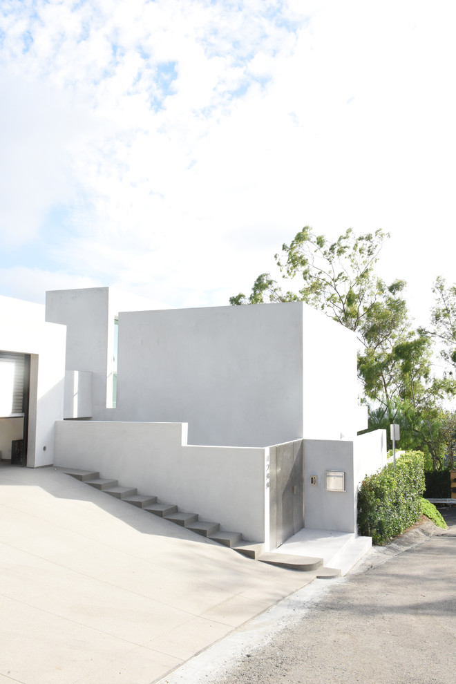 This is an example of a mid-sized contemporary two-storey stucco white exterior in Los Angeles with a flat roof.