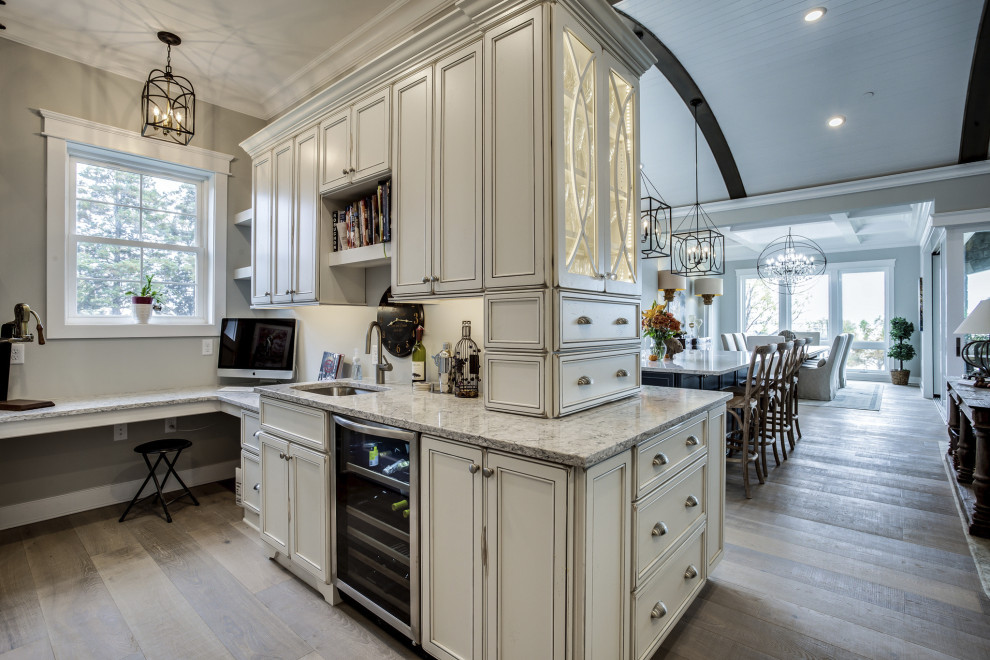 Large transitional l-shaped wet bar in Baltimore with an undermount sink, flat-panel cabinets, white cabinets, quartz benchtops, light hardwood floors, brown floor and multi-coloured benchtop.