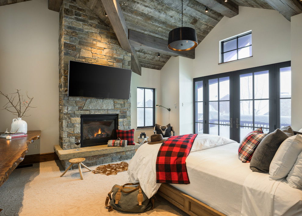 Mountain style carpeted bedroom photo with white walls and a standard fireplace