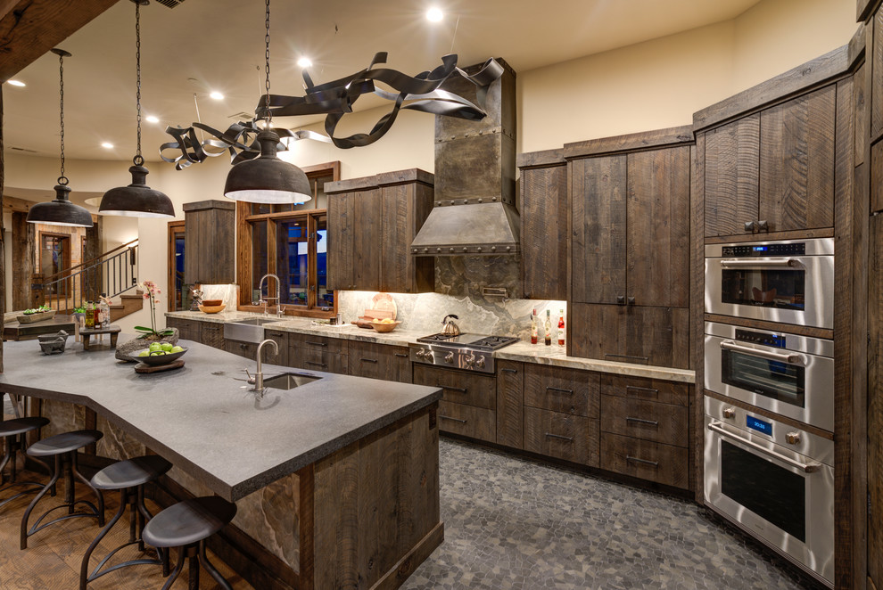 Design ideas for a country l-shaped kitchen in Salt Lake City with a farmhouse sink, flat-panel cabinets, dark wood cabinets, grey splashback, stone slab splashback, stainless steel appliances, with island, grey floor and grey benchtop.