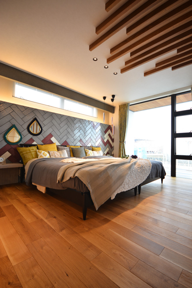 Photo of a scandinavian bedroom in Other with grey walls, medium hardwood floors, no fireplace, beige floor and wallpaper.