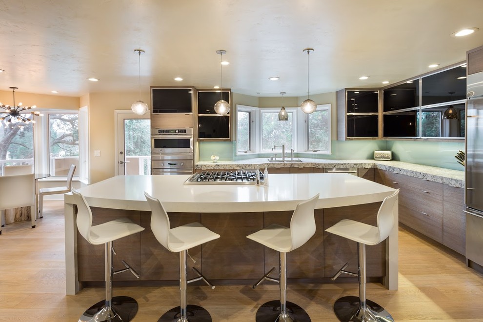 Photo of a large eclectic eat-in kitchen in San Francisco with an undermount sink, glass-front cabinets, black cabinets, quartz benchtops, stainless steel appliances and with island.