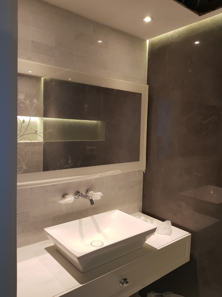 Example of a mid-sized minimalist master gray tile walk-in shower design with louvered cabinets, white cabinets, a hot tub, marble countertops and black countertops