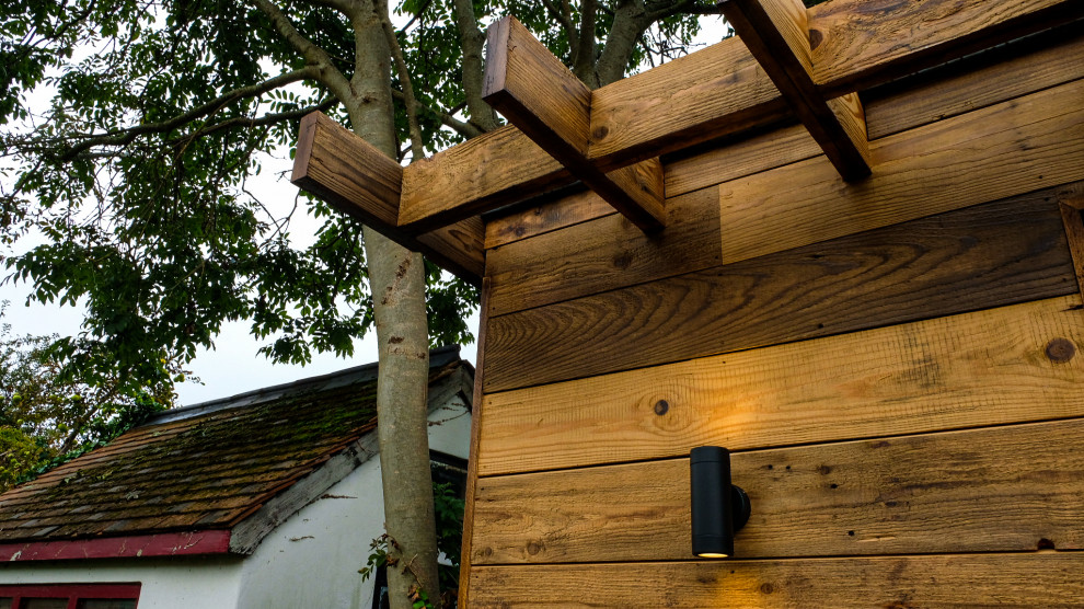 На фото: маленькая отдельно стоящая хозпостройка в стиле рустика с мастерской для на участке и в саду