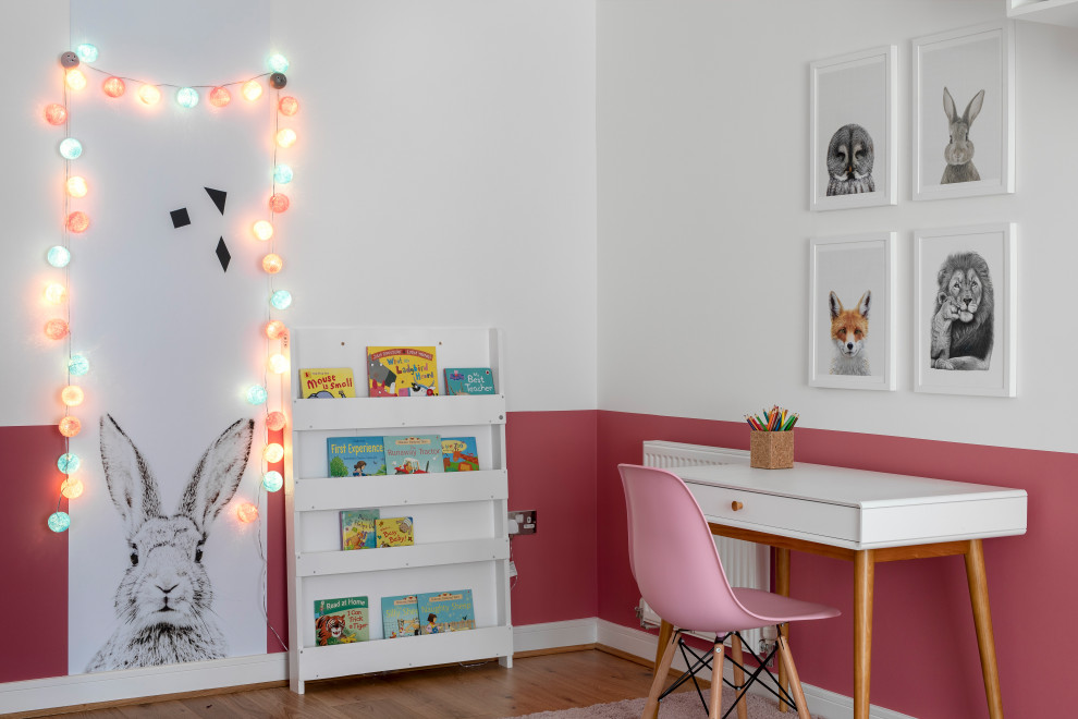 Photo of a mid-sized scandinavian kids' study room for kids 4-10 years old and girls in Kent with medium hardwood floors, brown floor and multi-coloured walls.