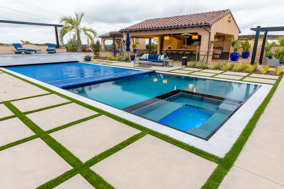 Ispirazione per una piscina monocorsia contemporanea rettangolare di medie dimensioni e dietro casa con una vasca idromassaggio e pavimentazioni in cemento