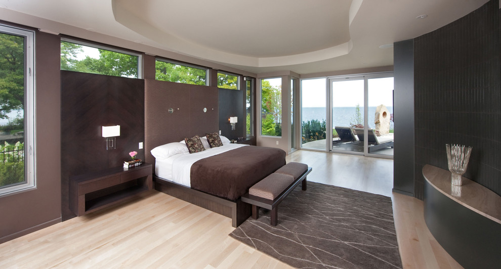 Inspiration for a contemporary bedroom in Toronto with black walls and light hardwood floors.