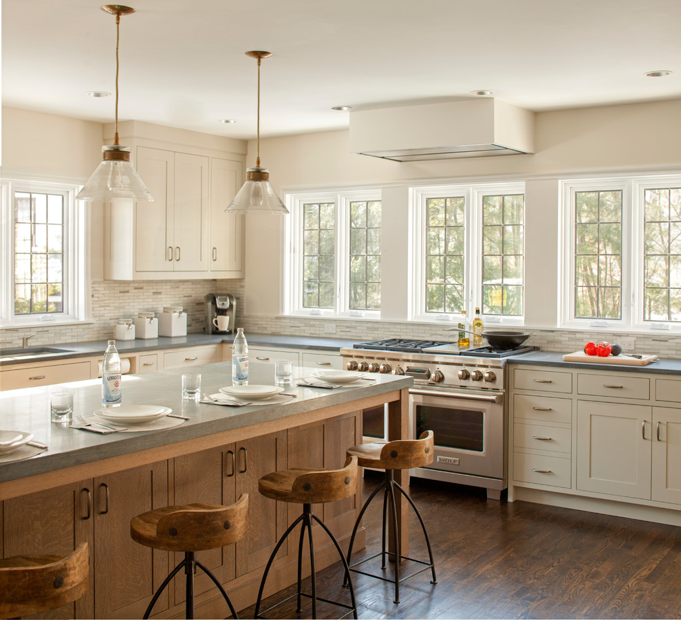 Inspiration for a large transitional l-shaped eat-in kitchen in New York with shaker cabinets, grey cabinets, limestone benchtops, beige splashback, mosaic tile splashback, stainless steel appliances, dark hardwood floors, with island and an undermount sink.