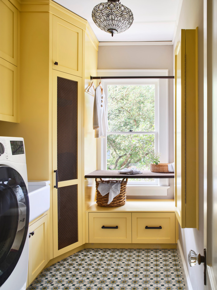 Mid-sized traditional laundry room in Other with a farmhouse sink, shaker cabinets, yellow cabinets and a side-by-side washer and dryer.